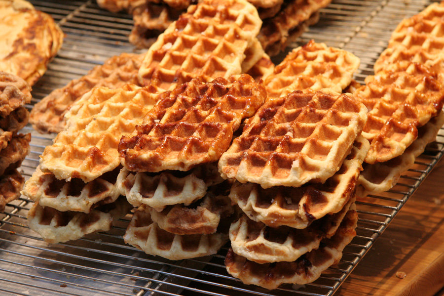 Neat stacks of Liege Belgian Waffles cooling on a storefront rack.